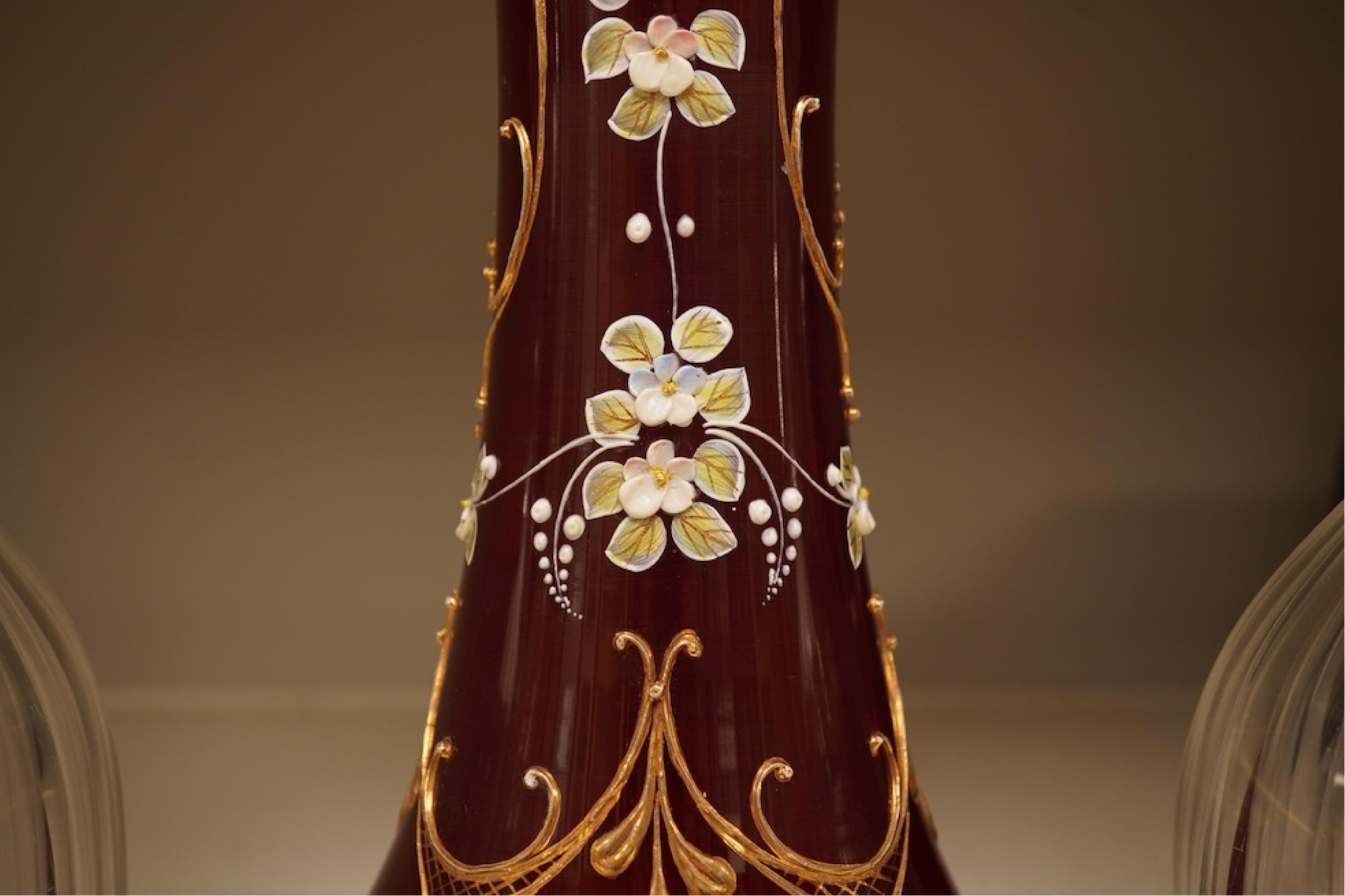 A pair of Victorian glass decanters, later stoppers, and an enamelled ruby glass vase, latter 32cm high